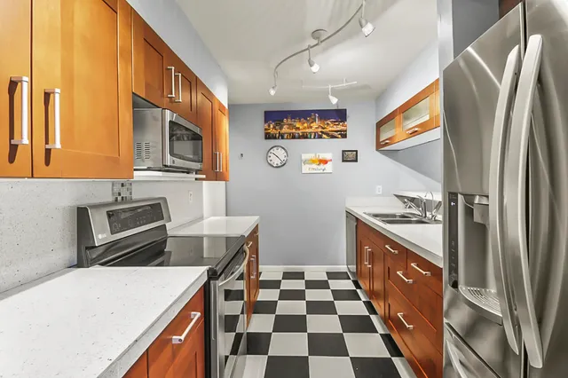 a kitchen with stainless steel appliances a stove a sink and a refrigerator