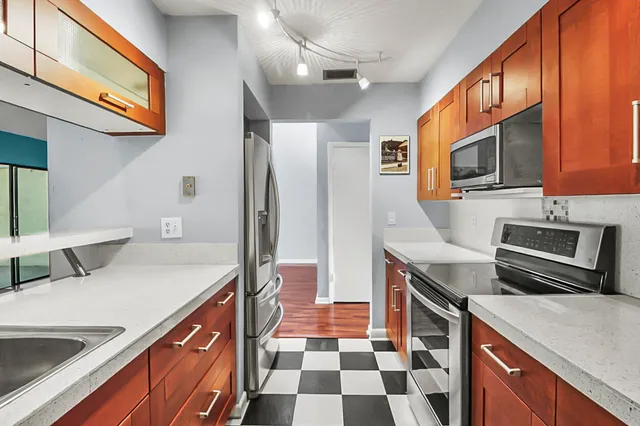 a kitchen with stainless steel appliances granite countertop a sink and a stove