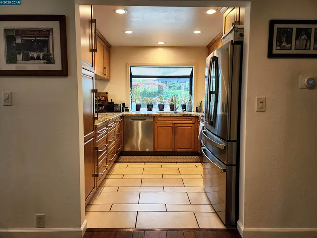 a kitchen with stainless steel appliances granite countertop a refrigerator and a stove