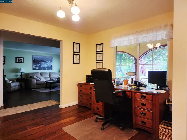 a view of a workspace with furniture and a window