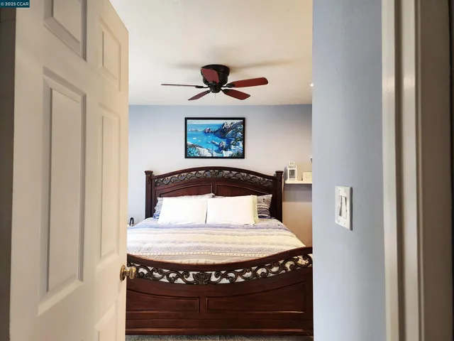 a bedroom with a bed and a painting on the wall