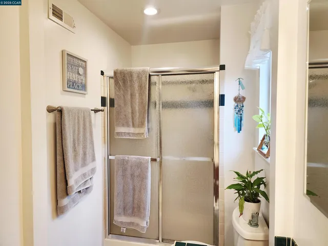 a bathroom with a shower and a glass door