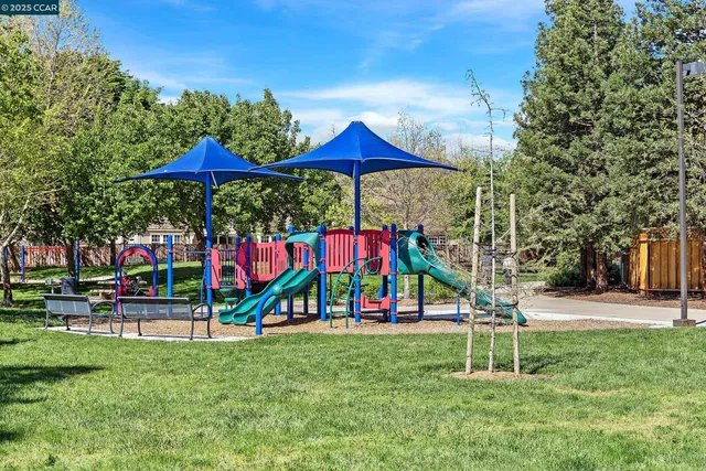 a view of a park with swings and a bench