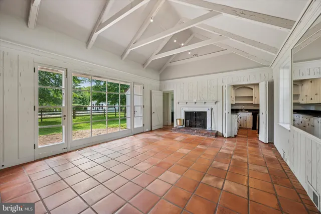 a view of an empty room with window and fire place
