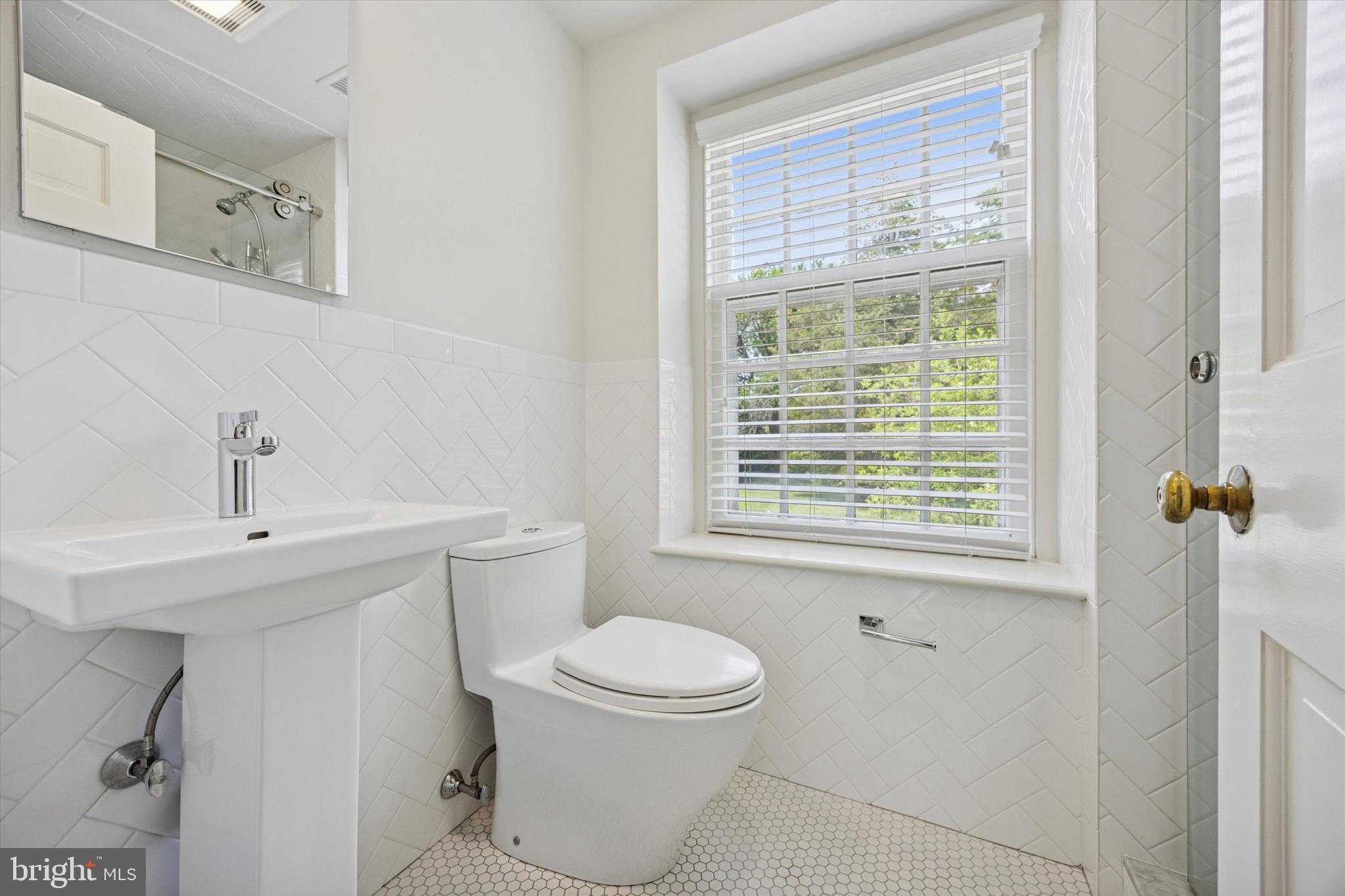 1024 North Spring Mill Road Villanova, PA 19085 - Photo 17 of 34 a bathroom with a toilet a sink and a window