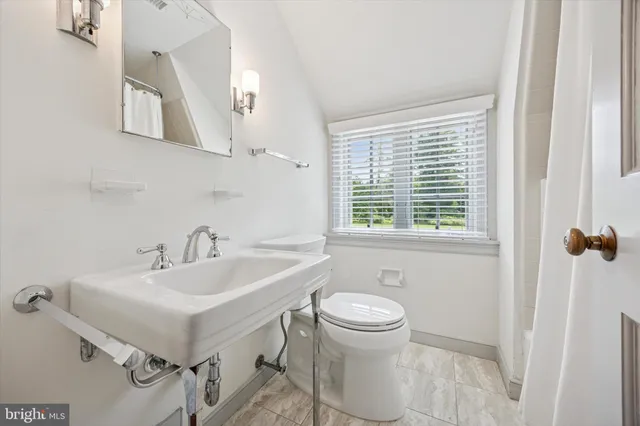 a bathroom with a sink toilet and mirror