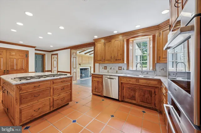 a large kitchen with stainless steel appliances granite countertop a stove and a sink