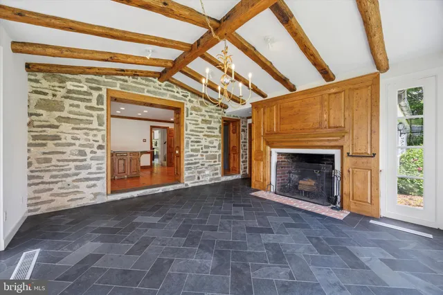 a view of an empty room with a fireplace and a window