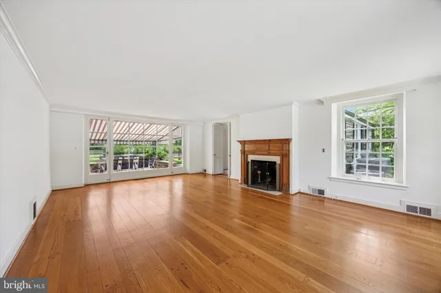 wooden floor fireplace and windows in an empty room