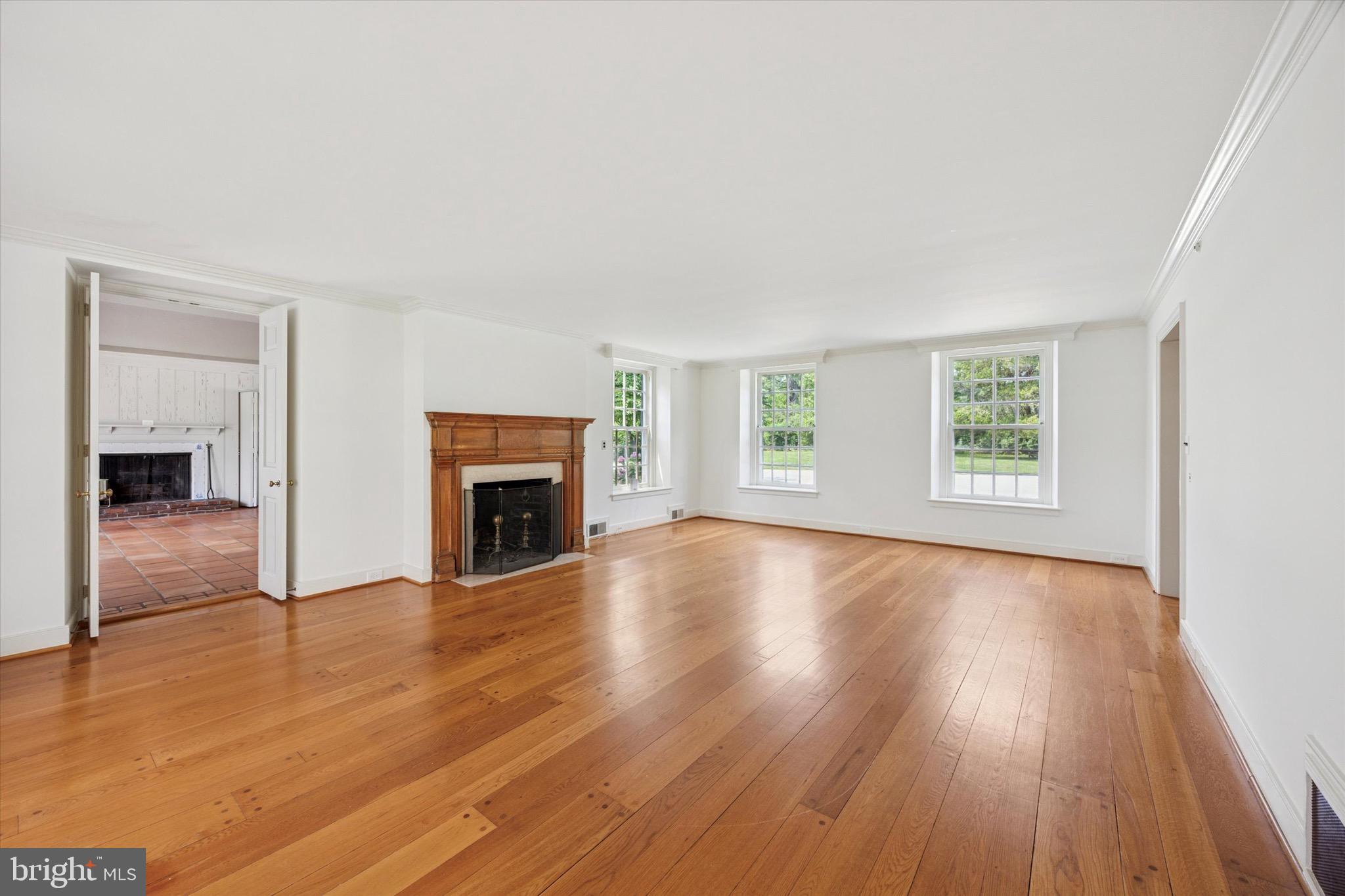 1024 North Spring Mill Road Villanova, PA 19085 - Photo 9 of 34 an empty room with wooden floor fireplace and windows