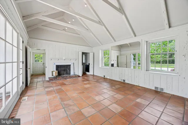 a view of an empty room with window and fire place