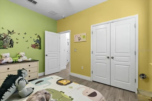 a bedroom with a large bed and a potted plant