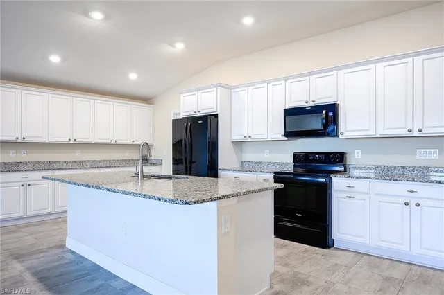 a view of kitchen with stainless steel appliances granite countertop a large counter top and a wooden floors