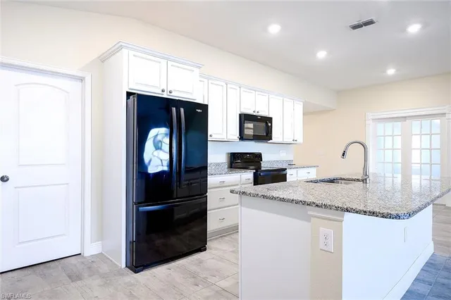 a kitchen with stainless steel appliances granite countertop a stove a sink and a refrigerator