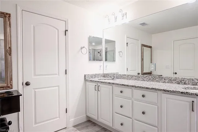 a bathroom with a granite countertop sink mirror bathtub and shower