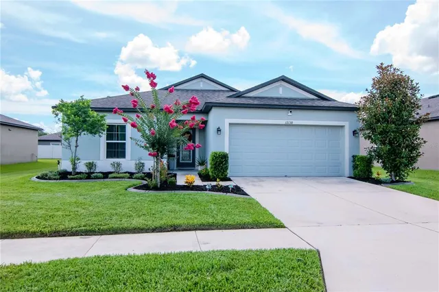 a front view of a house with a yard and garage