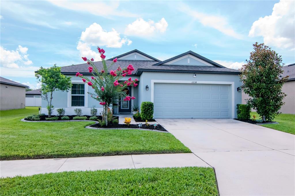 a front view of a house with a yard and garage