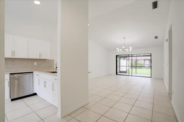 a view of a kitchen with dishwasher and white cabinets