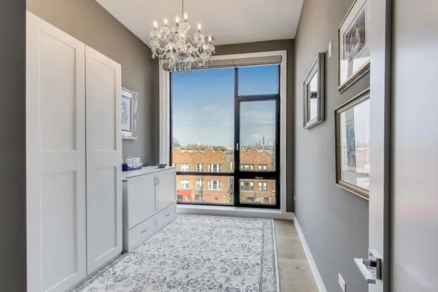 a view of a big room with windows and chandelier