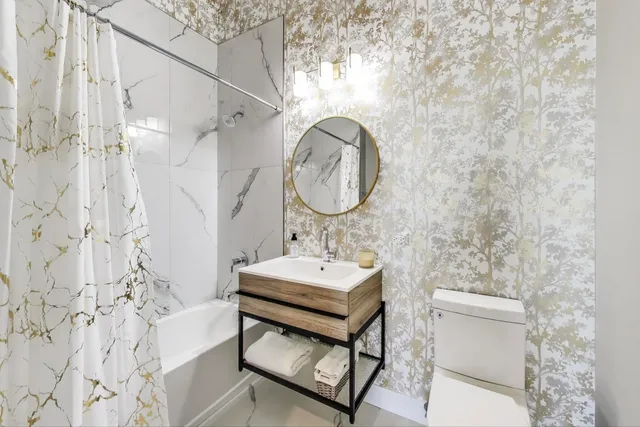 a bathroom with a sink a toilet and a mirror