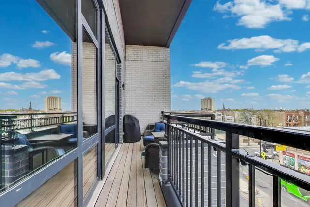 a view of a balcony with wooden chairs
