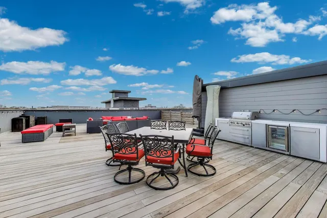 a view of roof deck with table and chairs