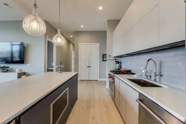 a kitchen with a sink dishwasher a stove and a refrigerator with wooden floor