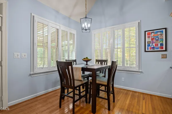 a dining room with furniture a chandelier and wooden floor