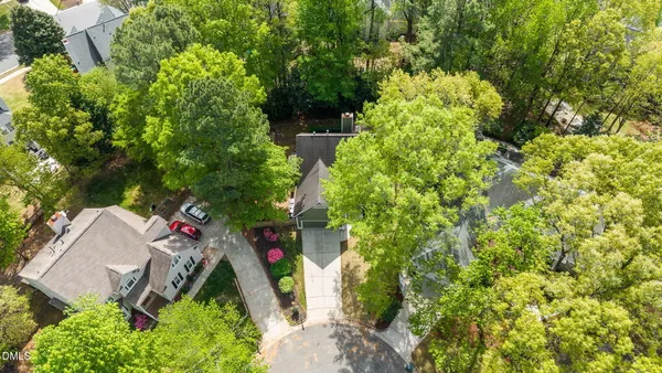 an aerial view of residential house with outdoor space and trees all around