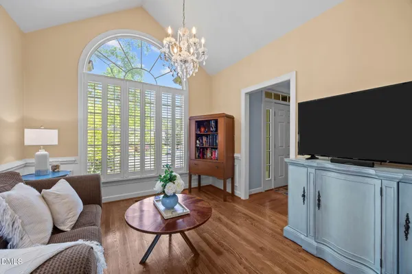 a living room with furniture a chandelier and a flat screen tv