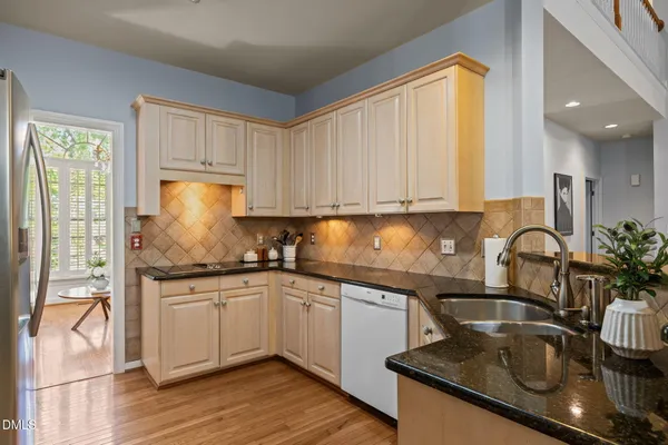 a kitchen with stainless steel appliances granite countertop a sink stove and cabinets