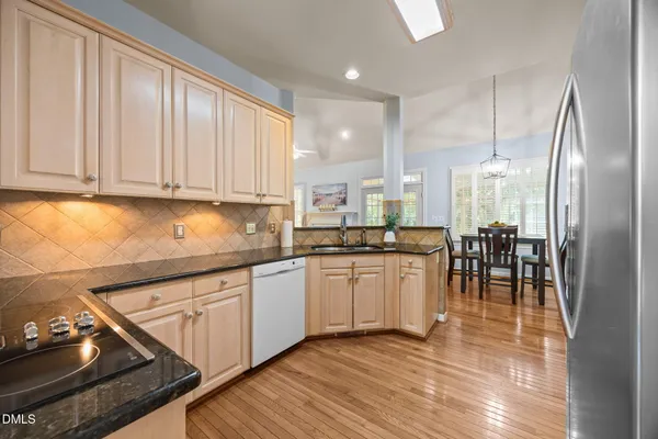 a kitchen with stainless steel appliances granite countertop a stove a sink and a refrigerator