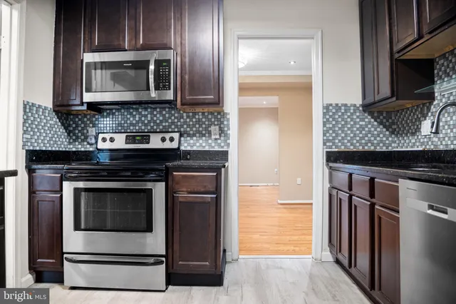 a kitchen with granite countertop a stove and a microwave