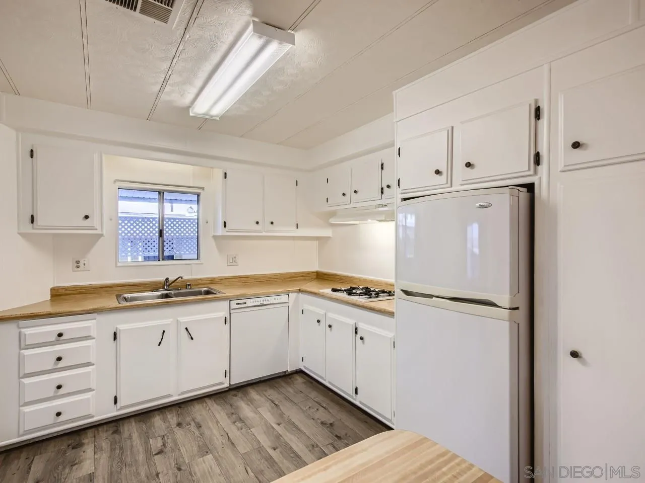 a kitchen with granite countertop white cabinets and white appliances
