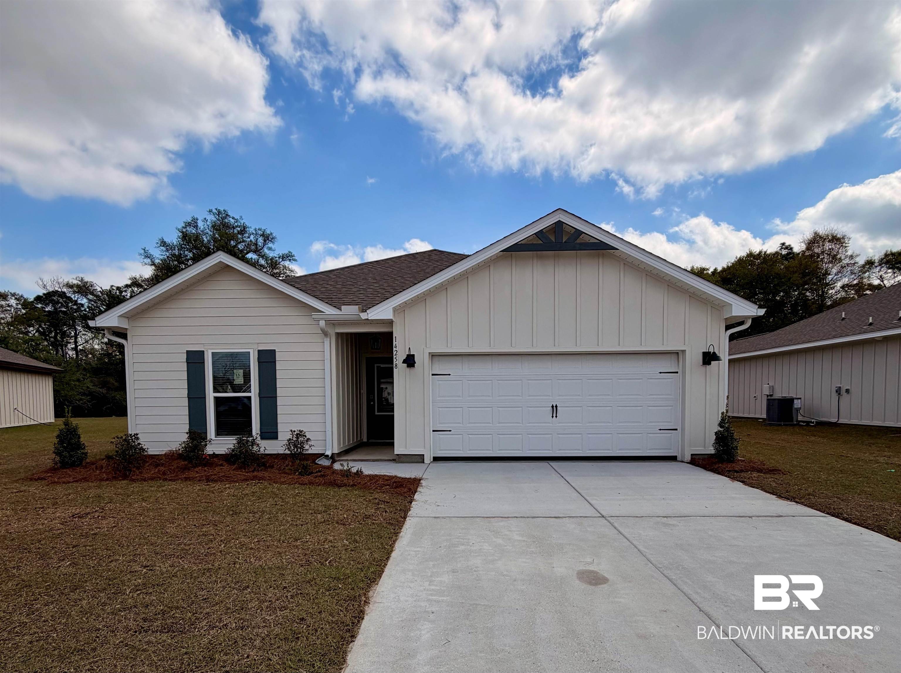 14258 Versailles Circle Silverhill, AL 36576 - Photo 1 of 36 Ranch-style house with a front yard, an attached garage, concrete driveway, and board and batten siding