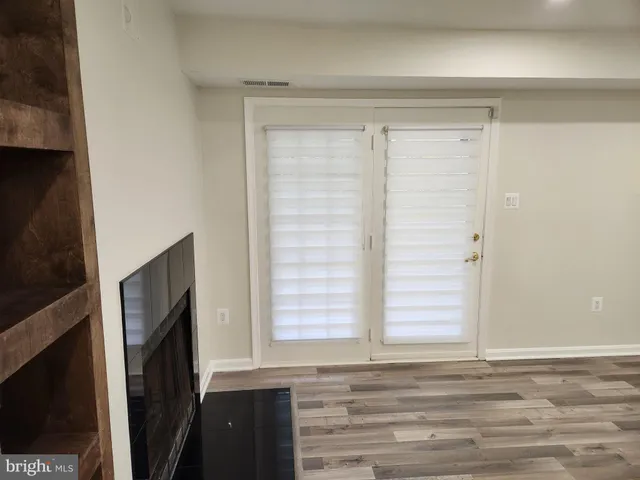 a kitchen with stainless steel appliances a sink a stove and white cabinets with wooden floor