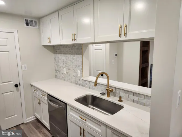 a kitchen with stainless steel appliances granite countertop a sink a stove and a refrigerator