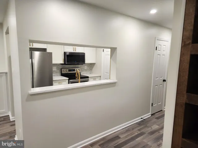 a large white kitchen with sink a refrigerator and microwave