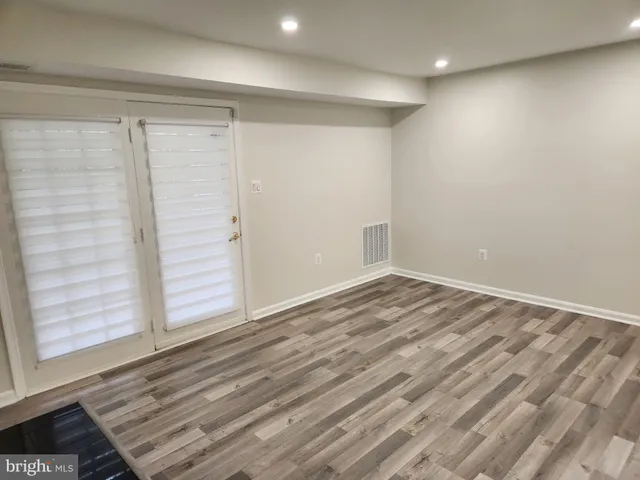 a view of a room with wooden floor and window