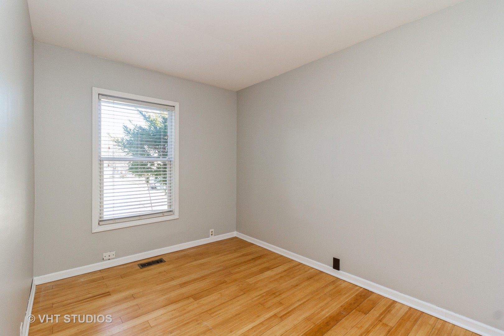 207 Haller Avenue Romeoville, IL 60446 - Photo 4 of 10 an empty room with wooden floor and windows