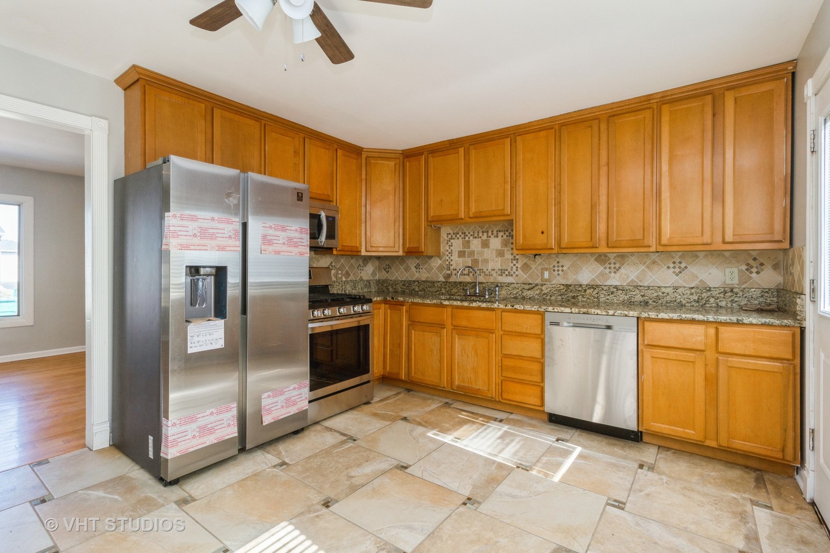 207 Haller Avenue Romeoville, IL 60446 - Photo 7 of 10 a kitchen with stainless steel appliances granite countertop a refrigerator a stove and a sink