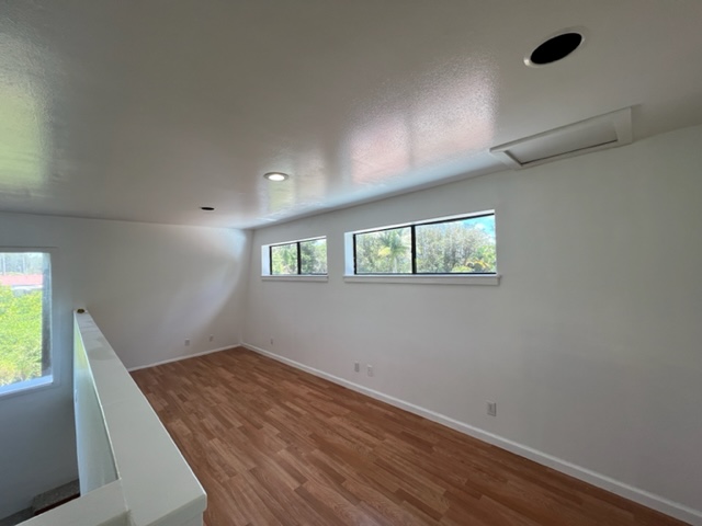 18-1976 Nau Nani Road Mountain View, HI 96771 - Photo 7 of 25 an empty room with wooden floor and windows
