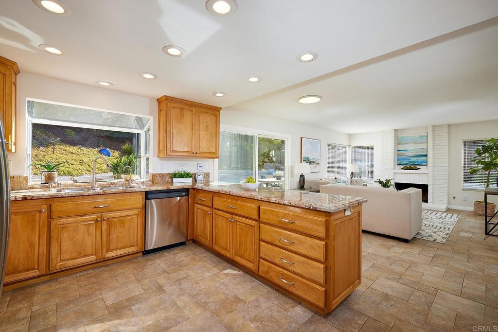 2107 Meadowgreen Court Encinitas, CA 92024 - Photo 12 of 49 a large kitchen with kitchen island a large counter top space a sink a window and stainless steel appliances
