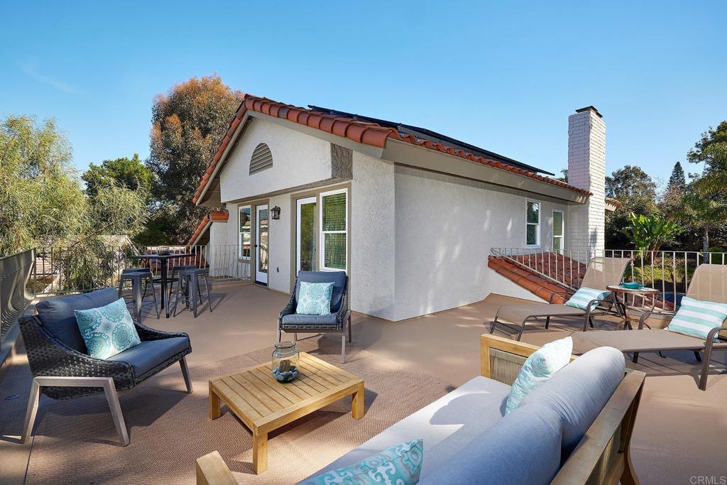 2107 Meadowgreen Court Encinitas, CA 92024 - Photo 29 of 49 a view of a patio with couches table and chairs with wooden floor and fence