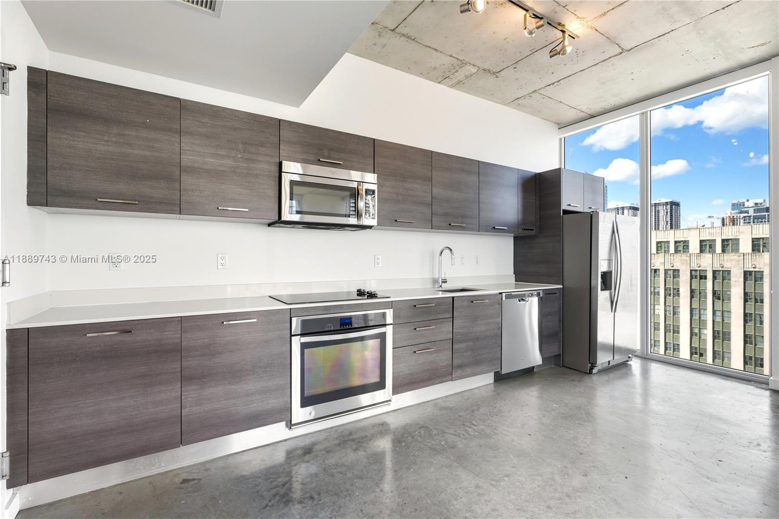 151 Southeast 1st Street, Unit 2002 Miami, FL 33131 - Photo 4 of 16 a kitchen with stainless steel appliances kitchen island granite countertop a stove and a sink