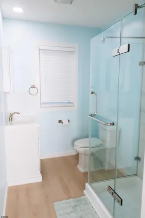 a bathroom with a sink a toilet and shower