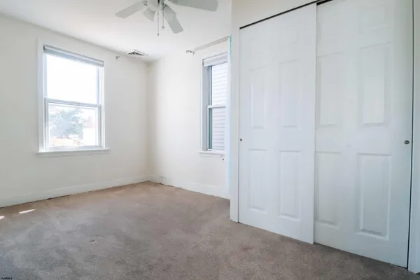 an empty room with windows and closet