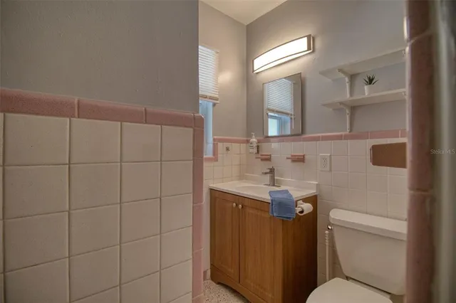 a bathroom with a granite countertop toilet sink and mirror
