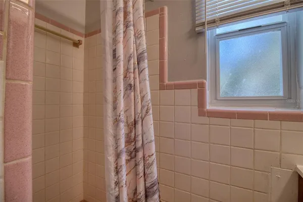 a bathroom with a shower curtain and a window