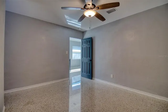 an empty room with closet and a chandelier fan